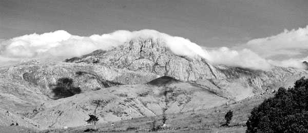 Massif rocheux, nuages et feux de brousses